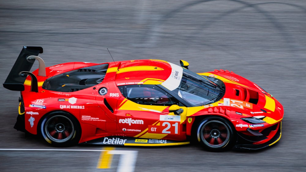 a red and yellow sports car driving on a race track