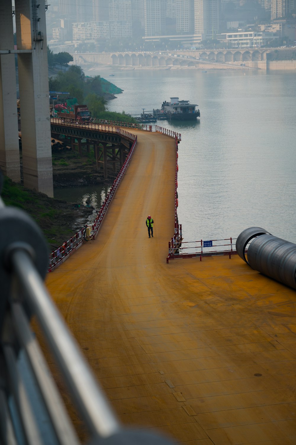 a person walking down a dirt road next to a body of water