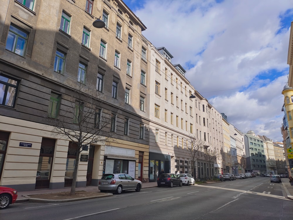 a city street lined with tall buildings and parked cars