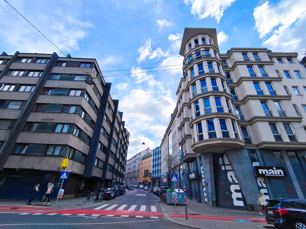 a city street lined with tall buildings under a cloudy blue sky