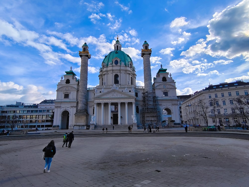 two people walking in front of a large building