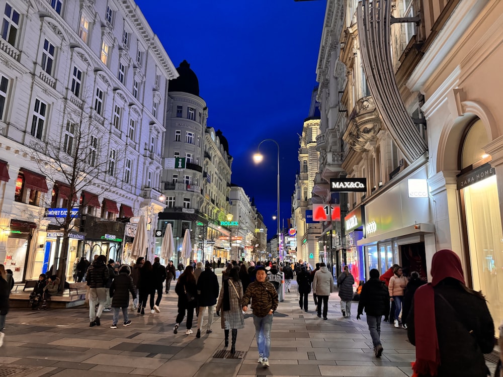 a group of people walking down a street next to tall buildings