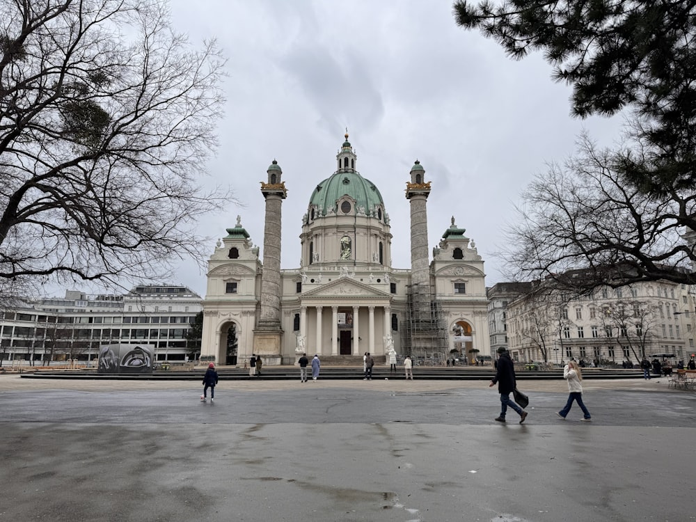 two people walking in front of a large building