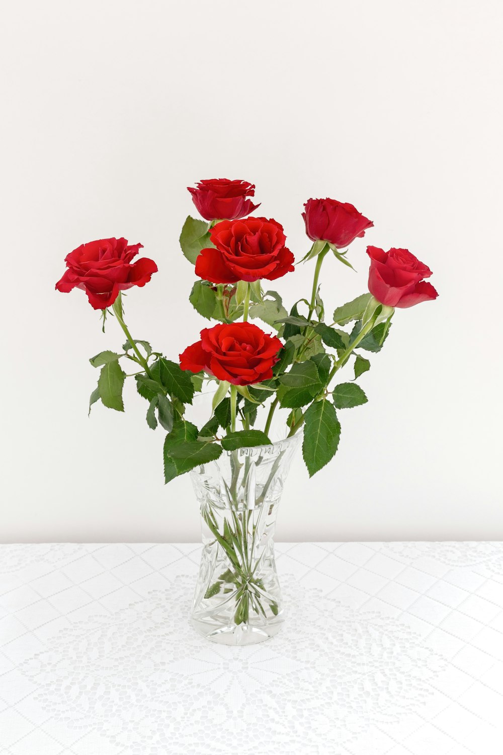 a vase filled with red roses on top of a table