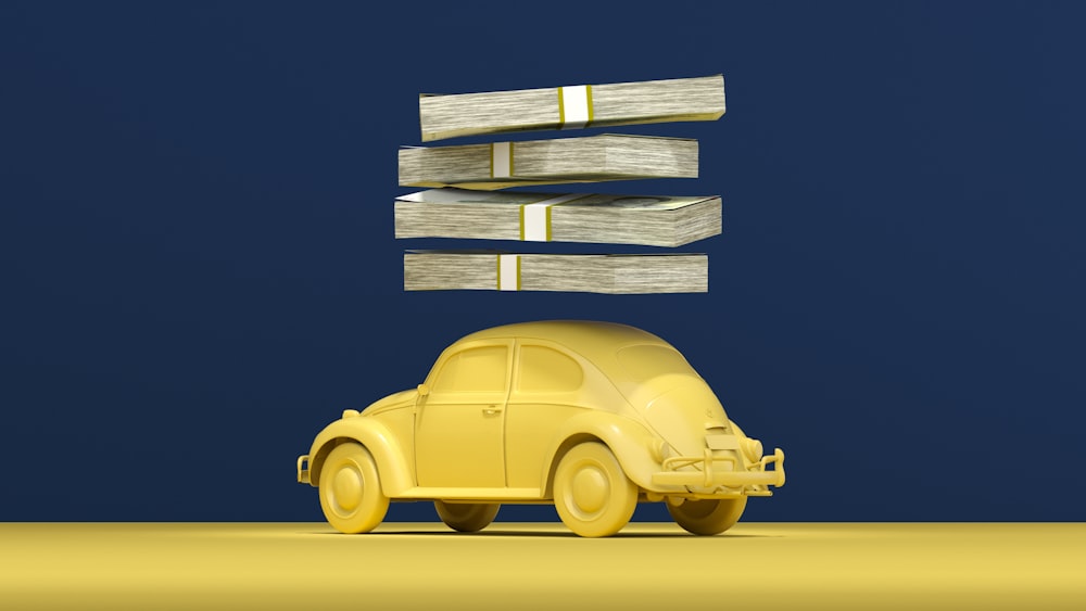a yellow car with stacks of money on top of it