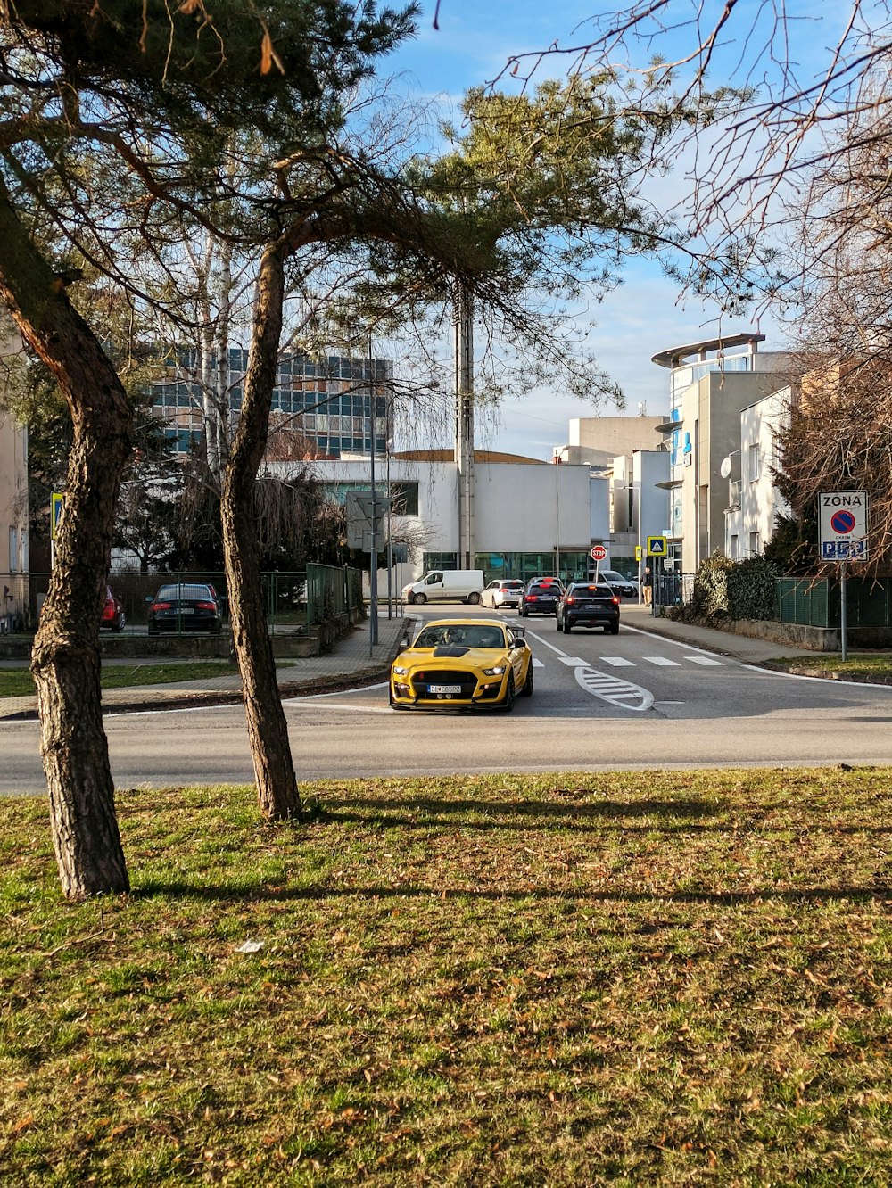 a yellow sports car driving down a street