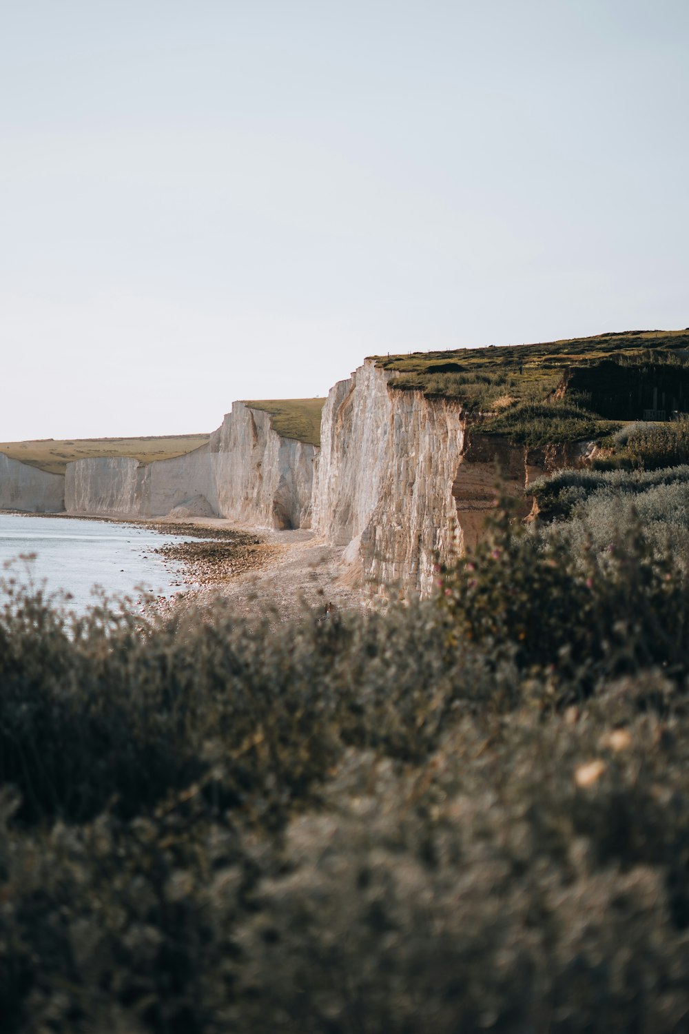 a view of a beach with a cliff in the background