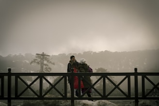 a couple of people walking across a bridge