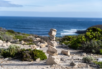 a stack of rocks sitting on top of a sandy beach
