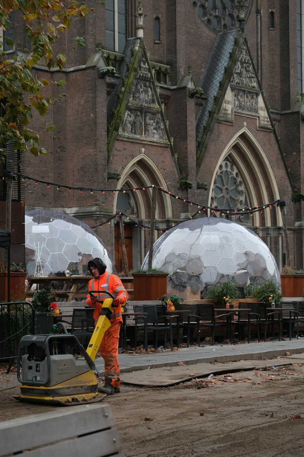 a man in an orange uniform is cleaning a street