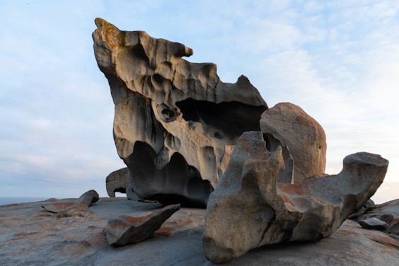a rock formation on a beach with a sky background