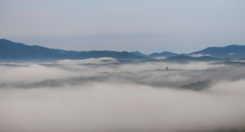 Une vallée brumeuse avec des montagnes au loin