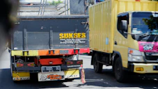 a yellow truck driving down a street next to a yellow truck