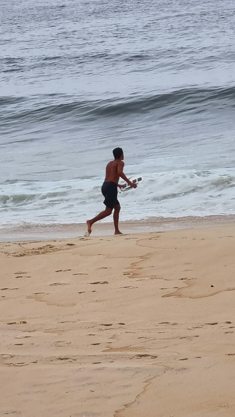 a man running on the beach with a baseball bat