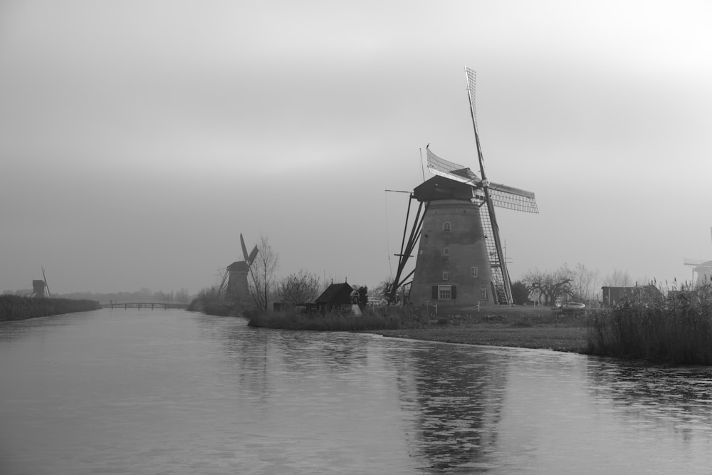 Une photo en noir et blanc d’un moulin à vent par temps de brouillard