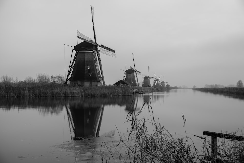 a black and white photo of windmills on a foggy day