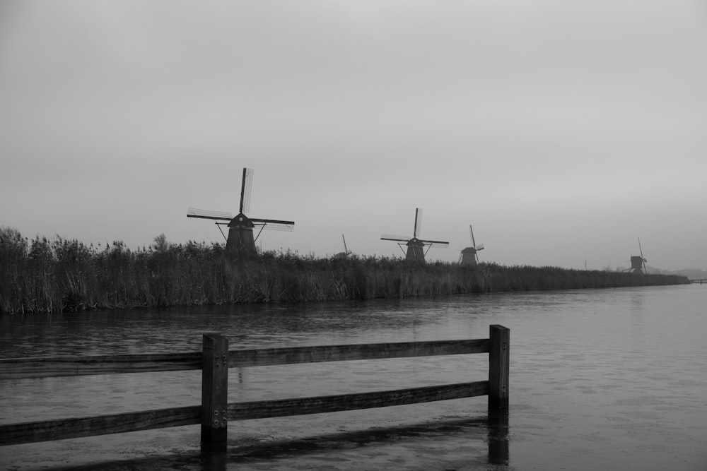 a black and white photo of a row of windmills