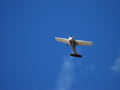 a small airplane flying through a blue sky