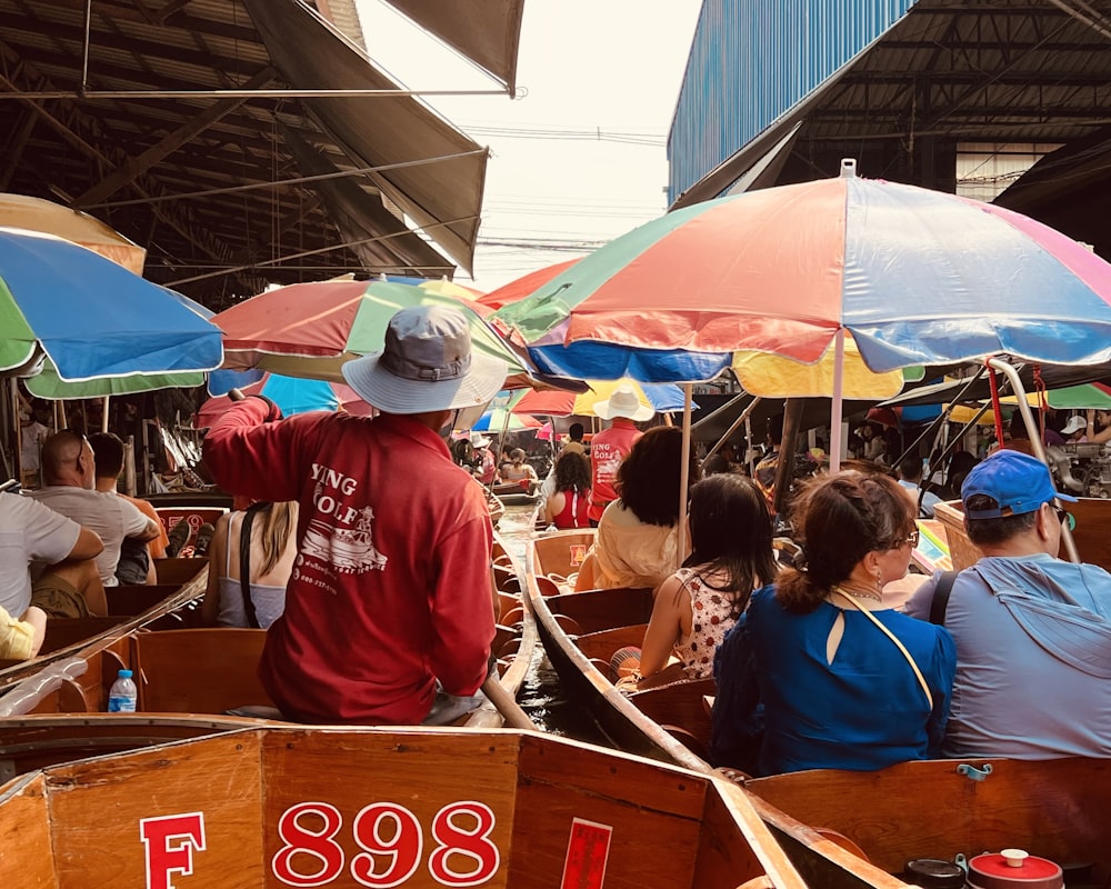 a group of people riding on top of wooden boats