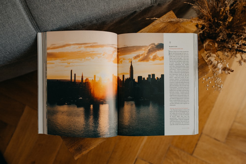an open book with a picture of a city at sunset