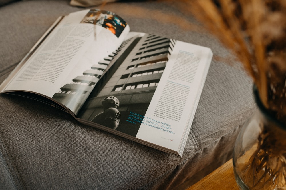 an open magazine sitting on top of a gray couch