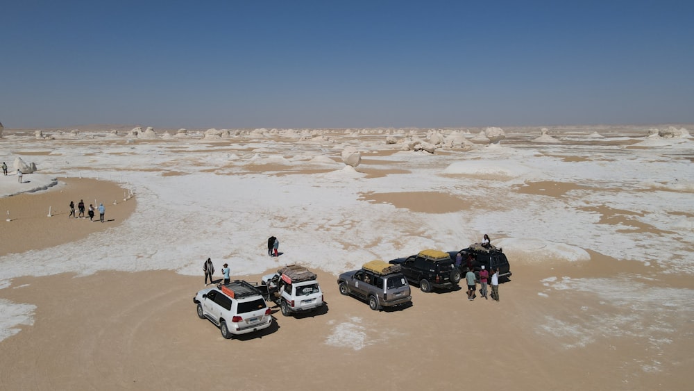 a group of people standing next to two trucks