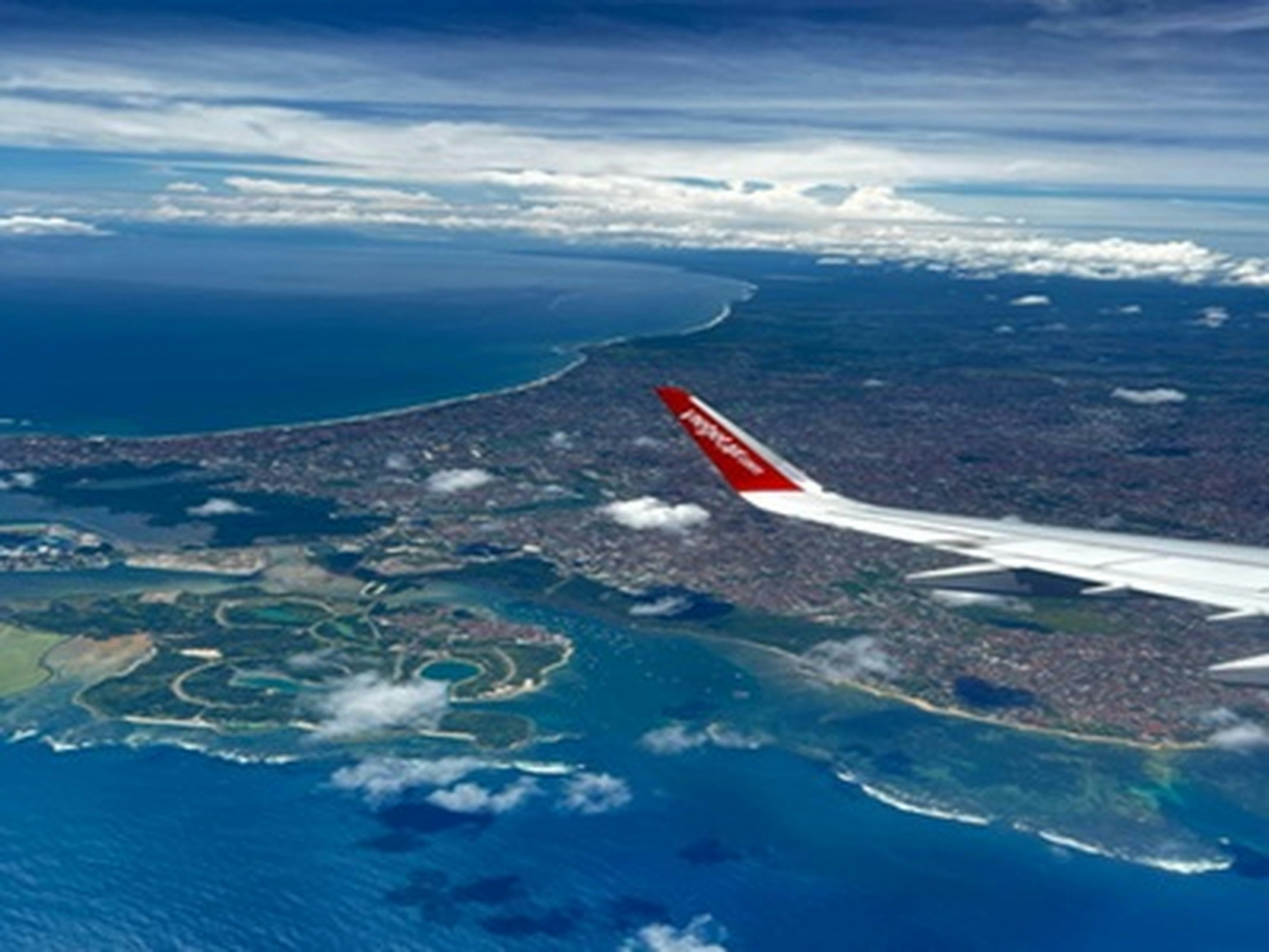 an airplane flying over a large body of water, Let