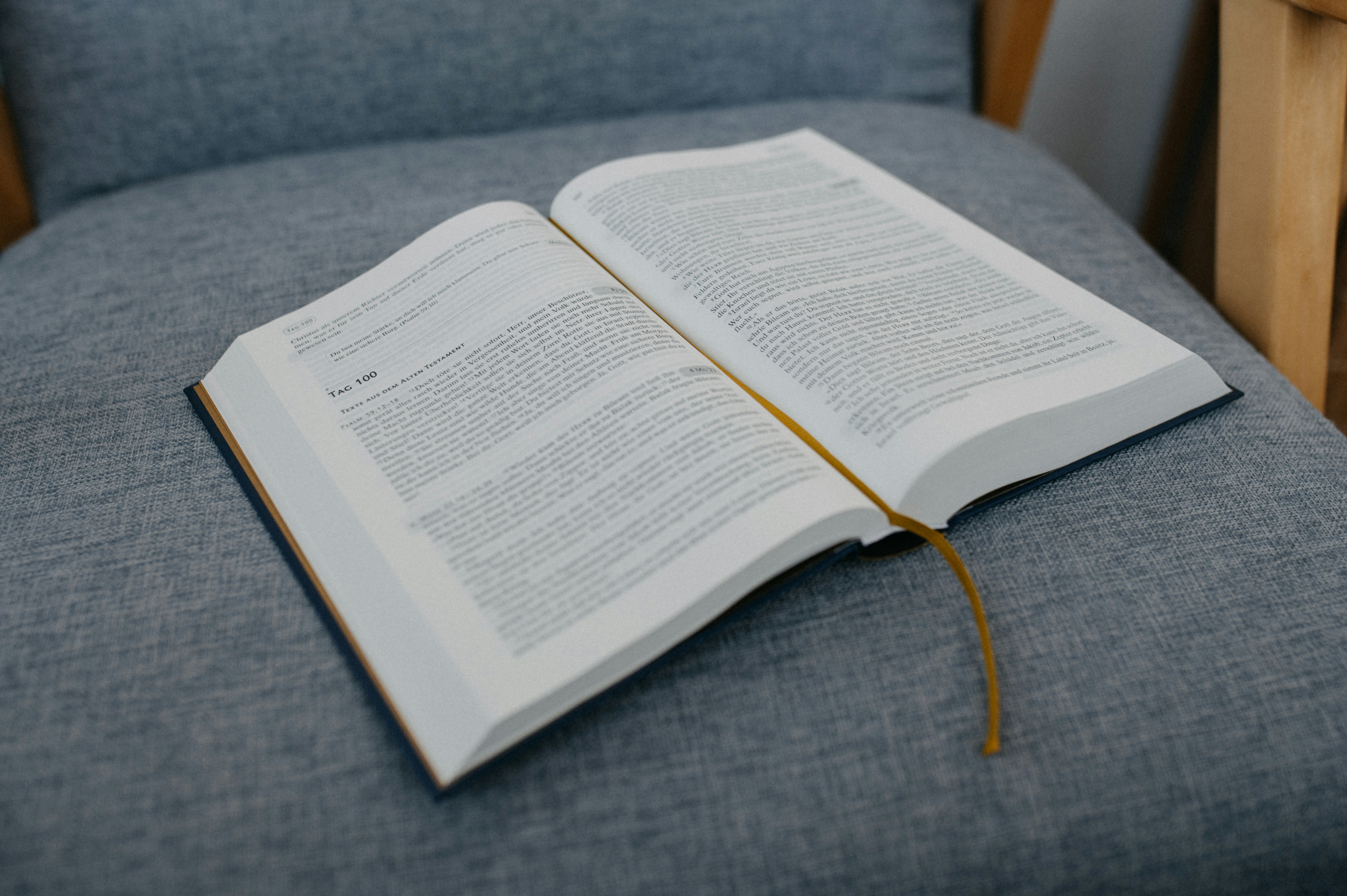 an open book sitting on top of a blue chair