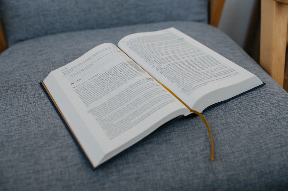 an open book sitting on top of a blue chair