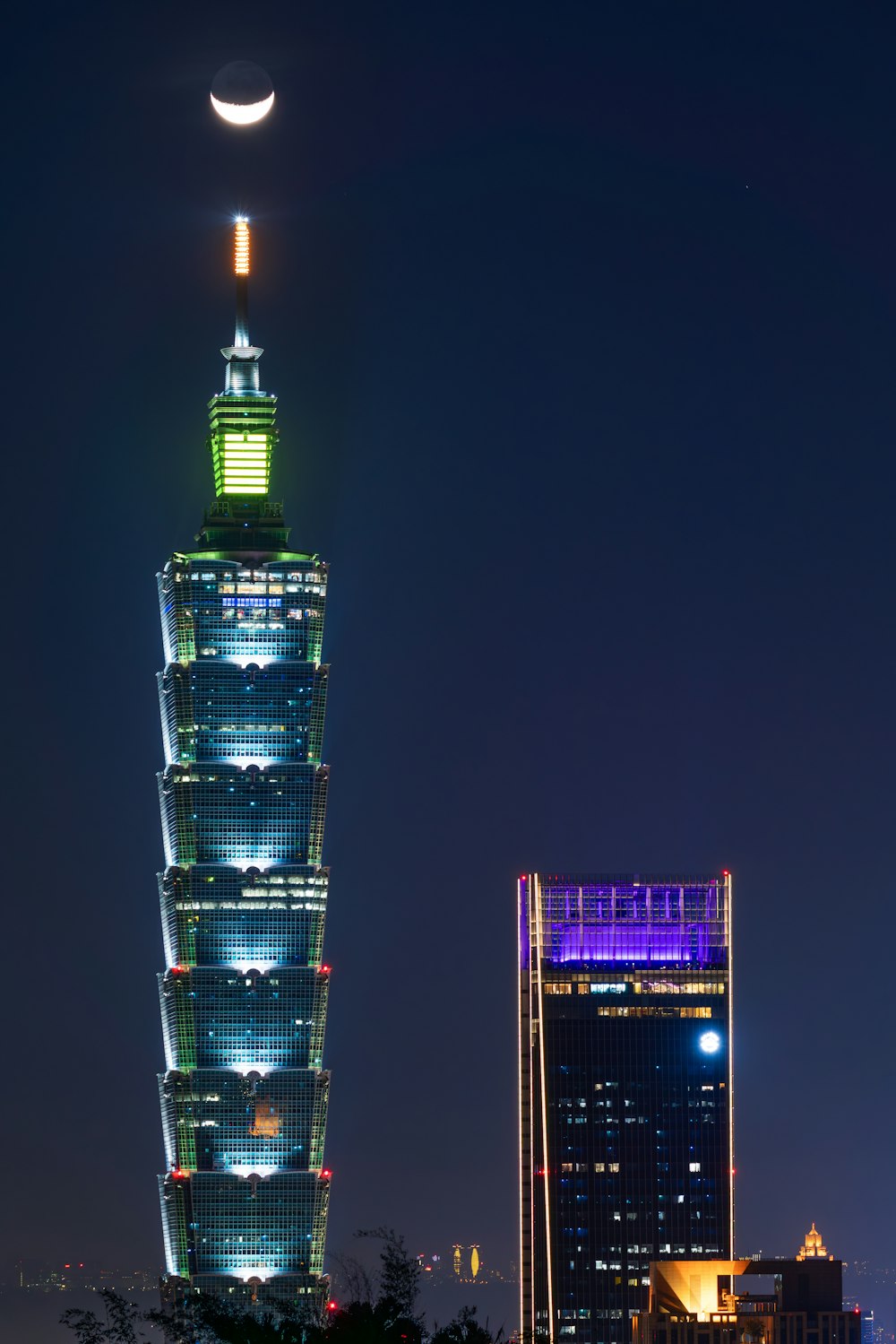 a very tall building with a moon in the sky