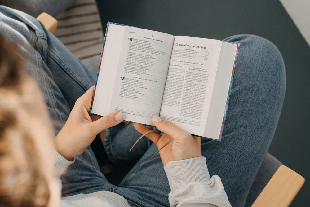 a woman sitting on a chair reading a book