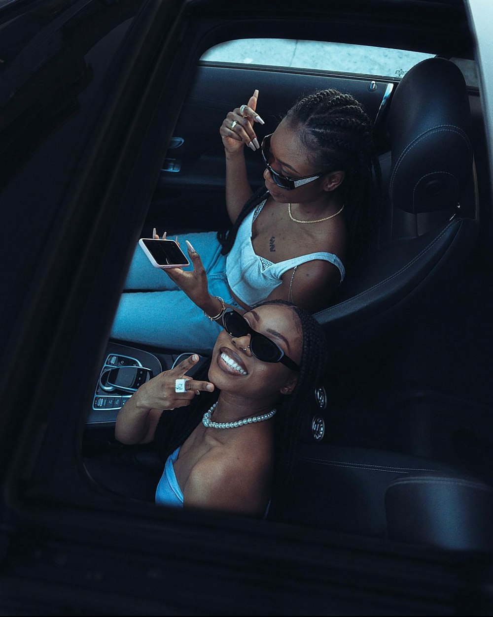 a couple of women sitting in a car next to each other