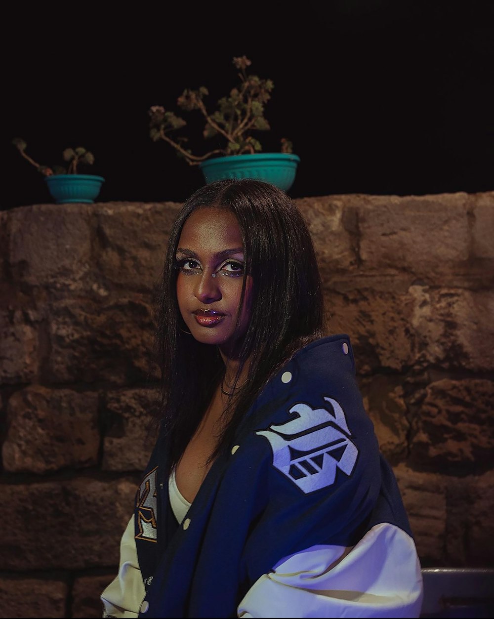 a woman wearing a jacket and a flower pot