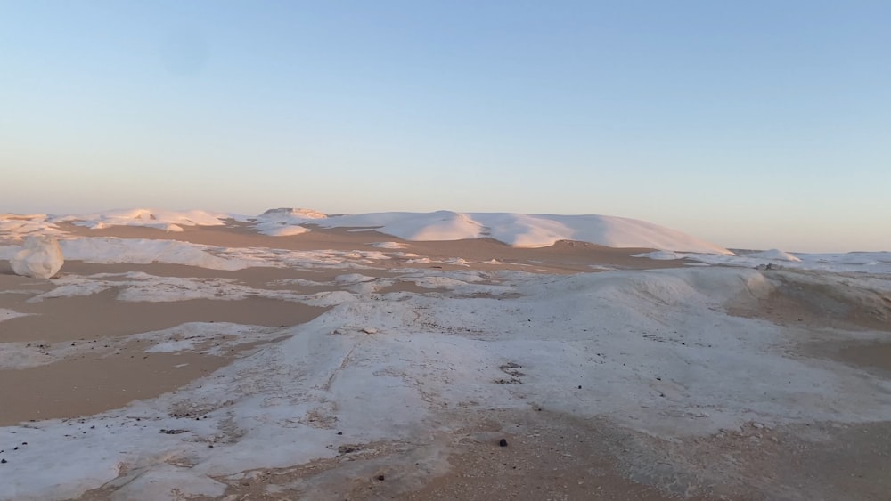 a snowy landscape with mountains in the distance