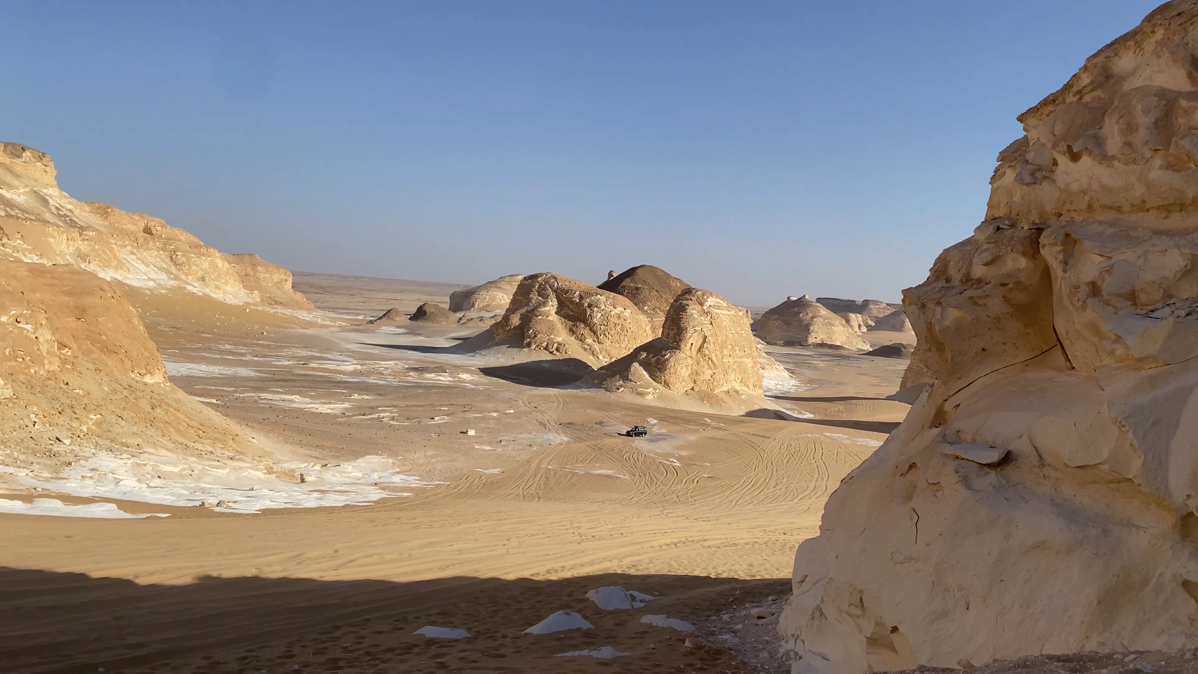 Wind-carved white chalk formations and sand in morning light in the White Desert, Egypt