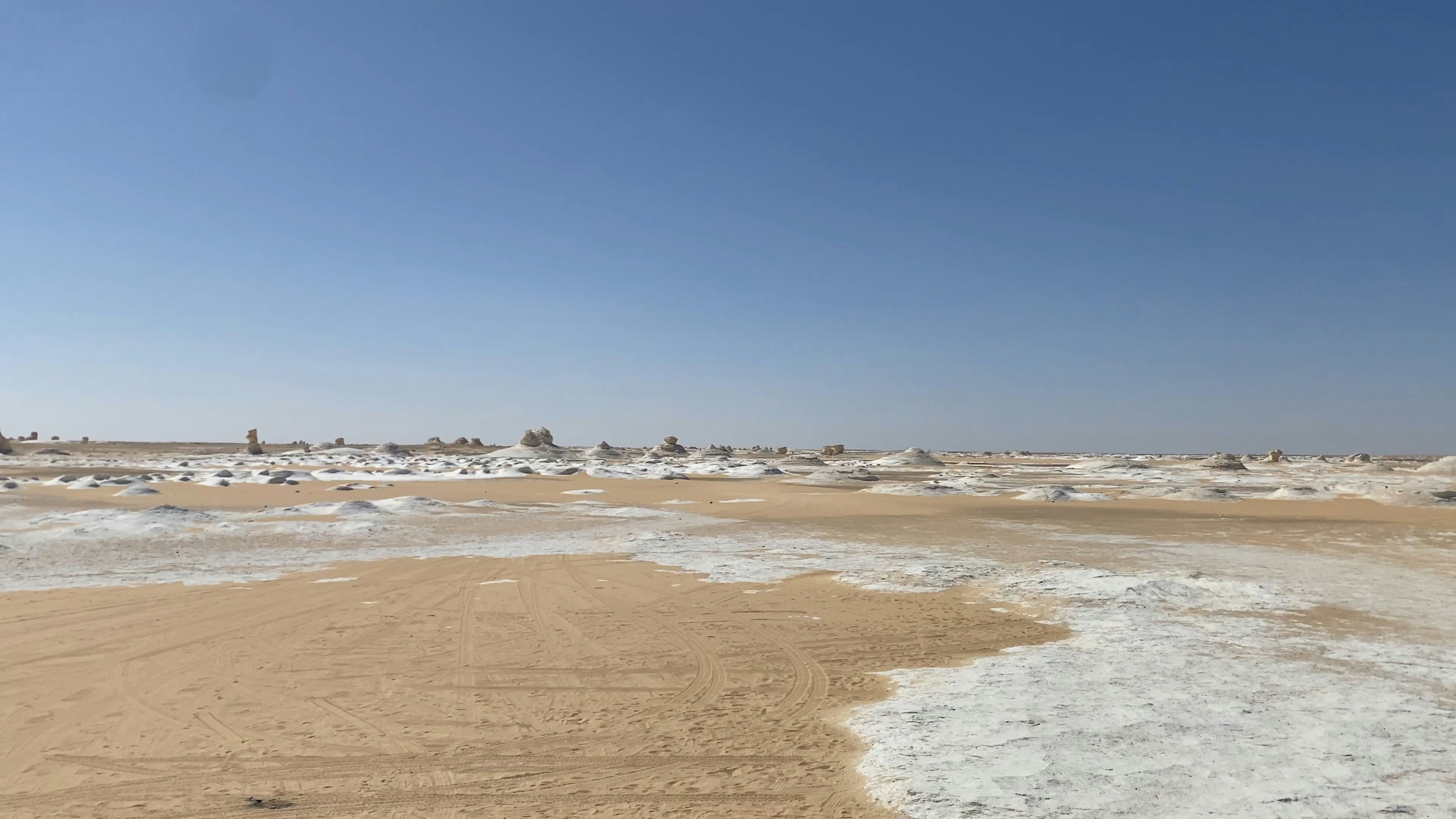 a sandy beach covered in snow under a blue sky, the white desert Egypt