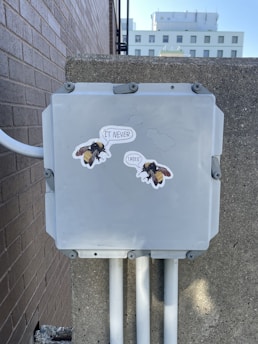 a gray box with stickers on the side of it