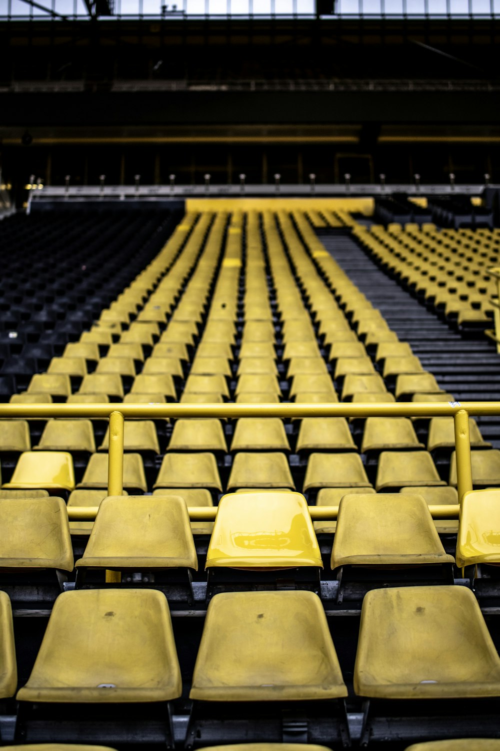 a row of empty yellow seats in a stadium