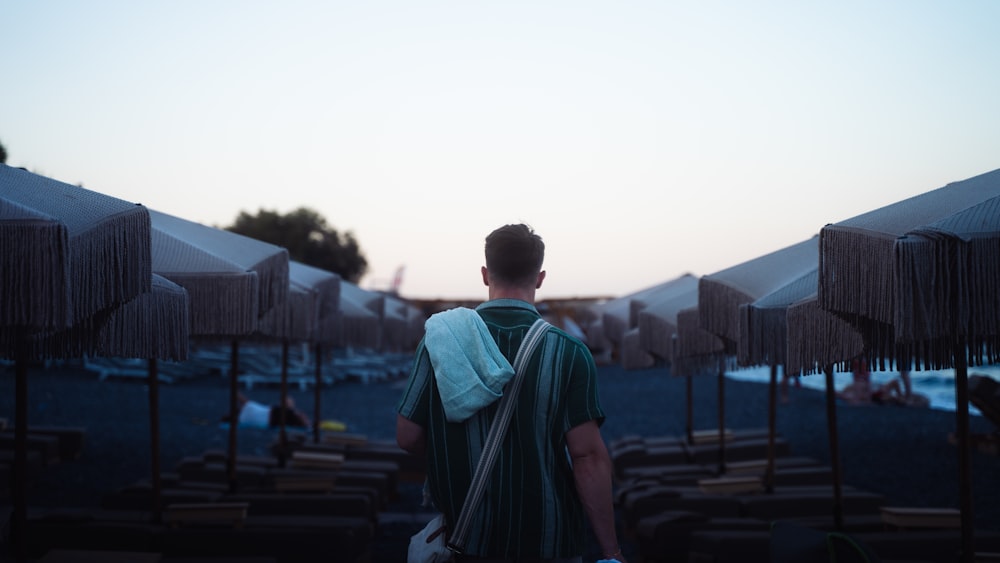 a man standing in front of a row of umbrellas