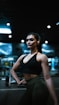 a woman standing in a gym with her hands on her hips