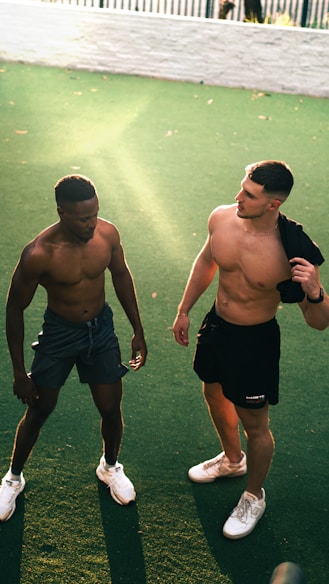 a couple of men standing on top of a green field