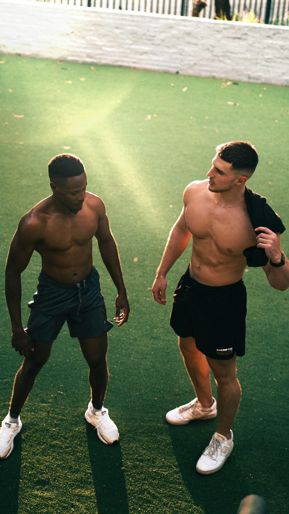 a couple of men standing on top of a green field