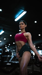 a woman in a red top and green skirt in a gym