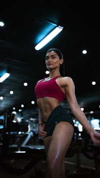 a woman in a red top and green skirt in a gym