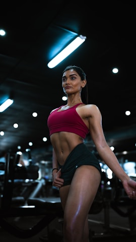 a woman in a red top and green skirt in a gym