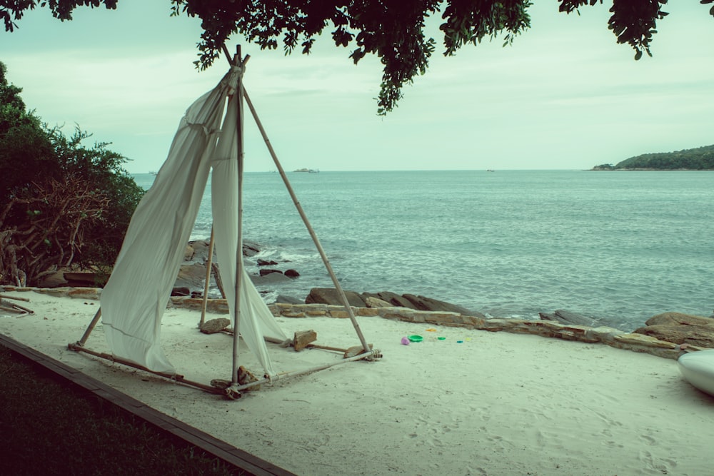 a tent set up on a beach near the ocean