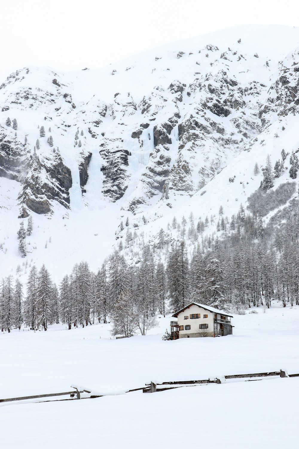 a house in the middle of a snowy field