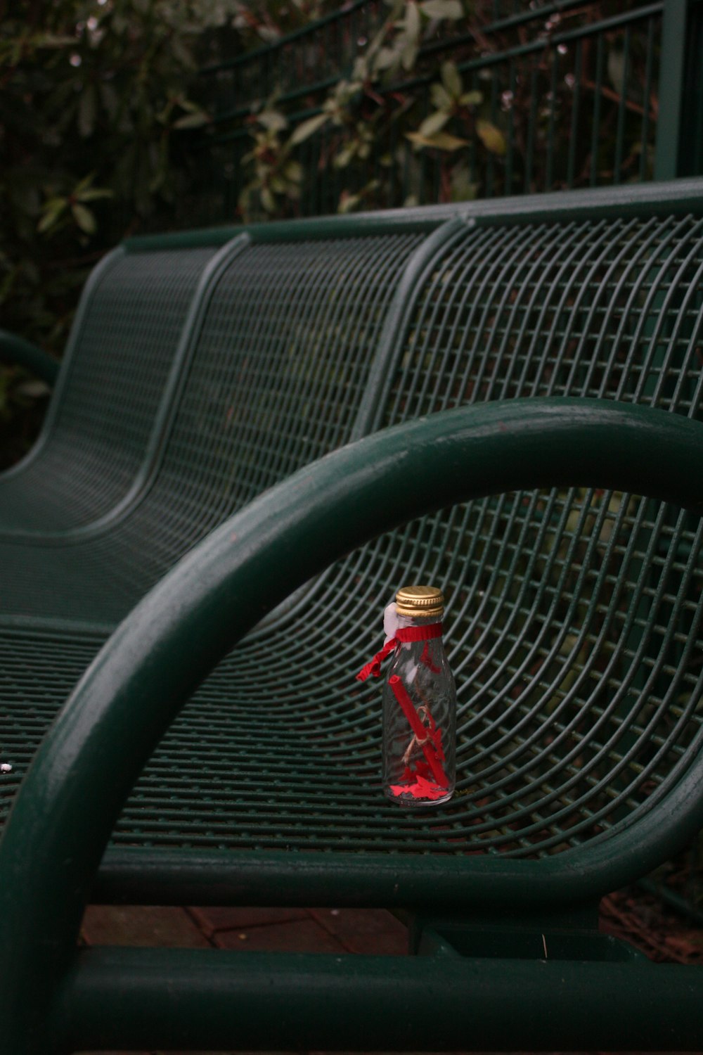 a bottle sitting on top of a green bench