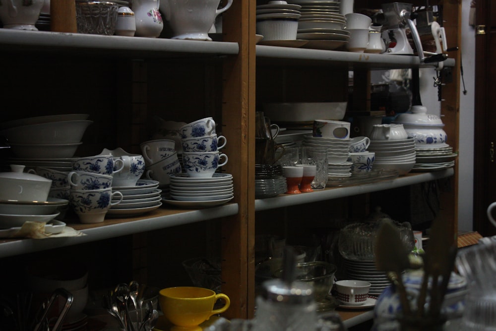 a shelf filled with lots of white and blue dishes