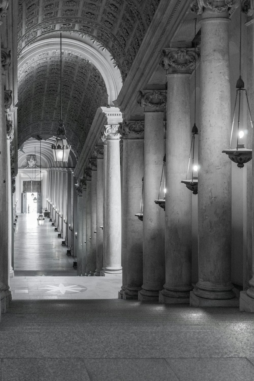 a black and white photo of a hallway in a building